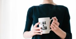 woman standing and holding white mug with the wirting "Like a boss"