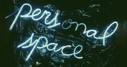 Neon sign "personal space" on black background