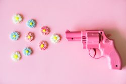 Pink toy plastic gun "shooting" colorful plastic flowers