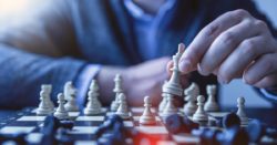 Person moving chess pieces on the board